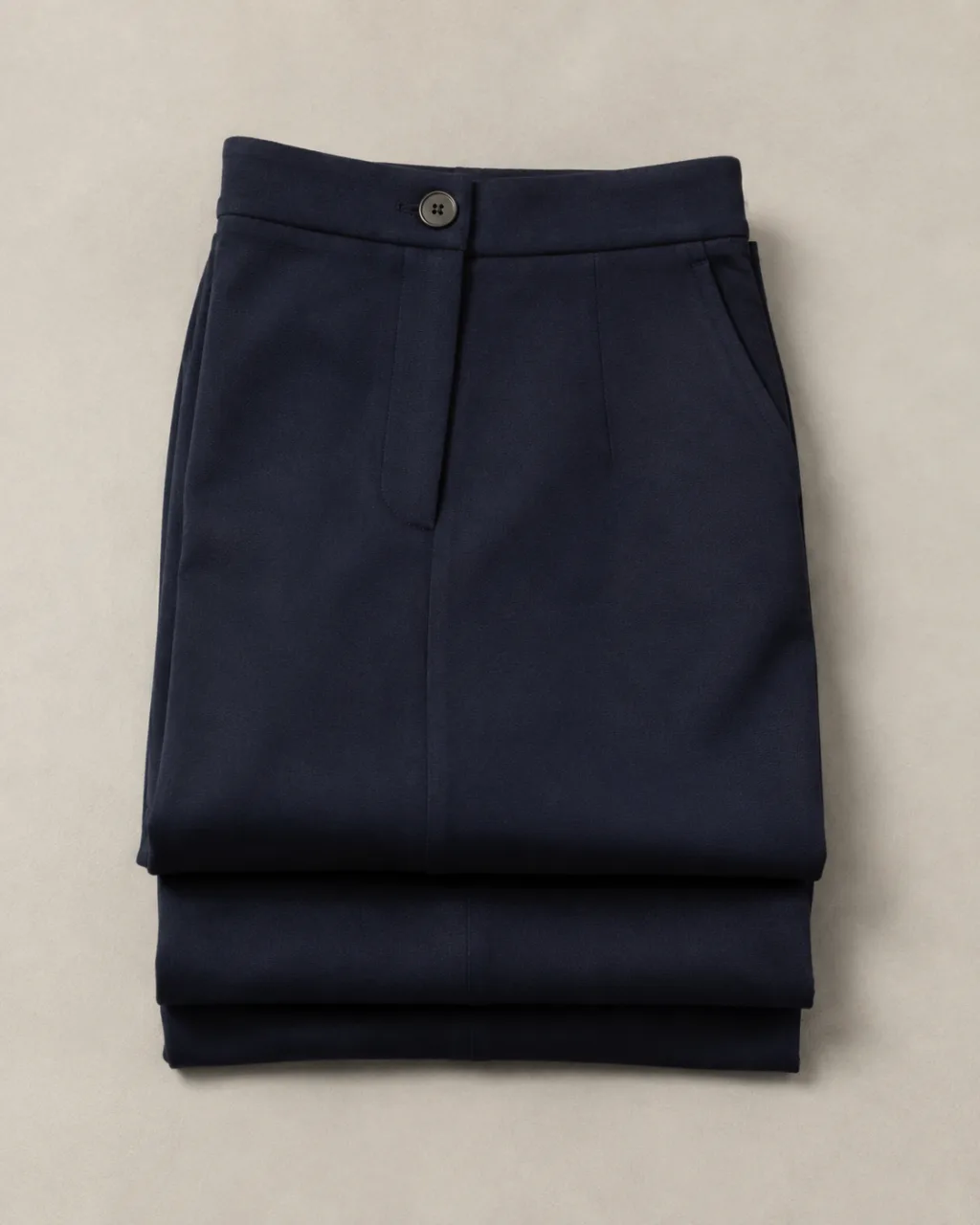 a pair of ponte knit pants folded in thirds, waistband facing the camera with a high rise and a button-and-zip waistband , fabric: Ponte double-knit