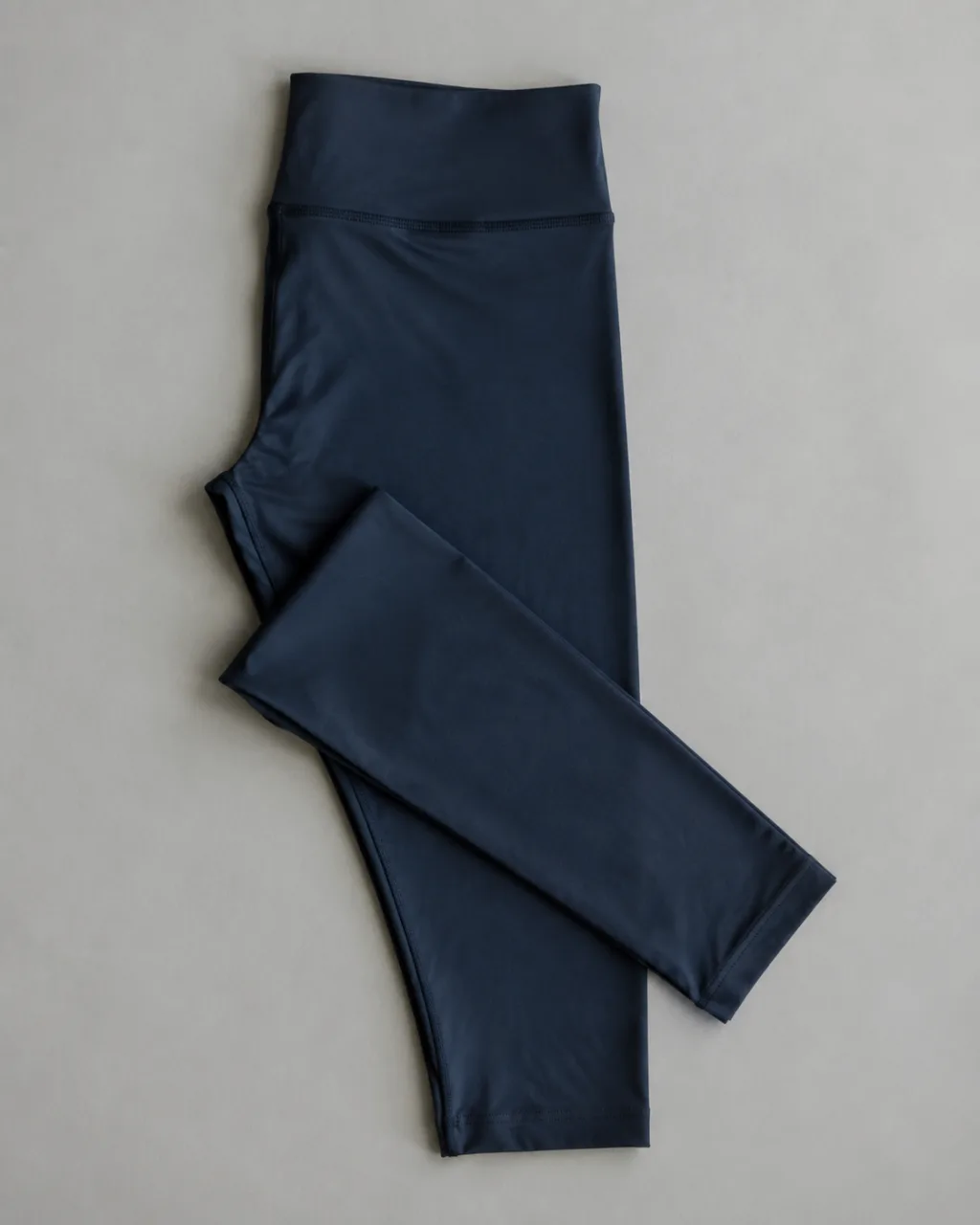 a pair of leggings laid flat with one leg folded back across the other with a full elastic waistband , fabric: FlexAppeal performance fabric