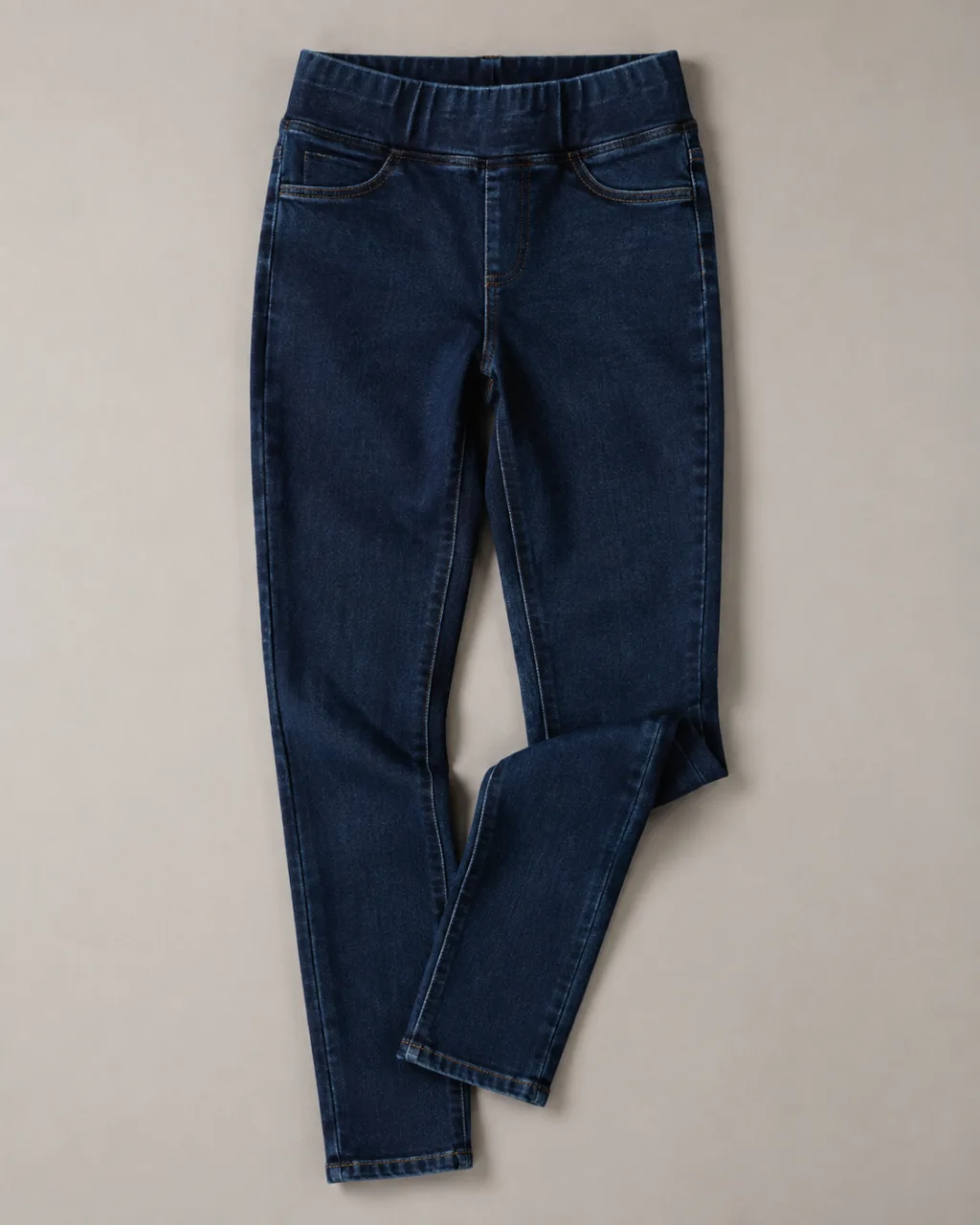 a pair of jeggings folded once at the knee and laid flat with a high rise and a full elastic waistband , fabric: Stretch cotton-blend denim