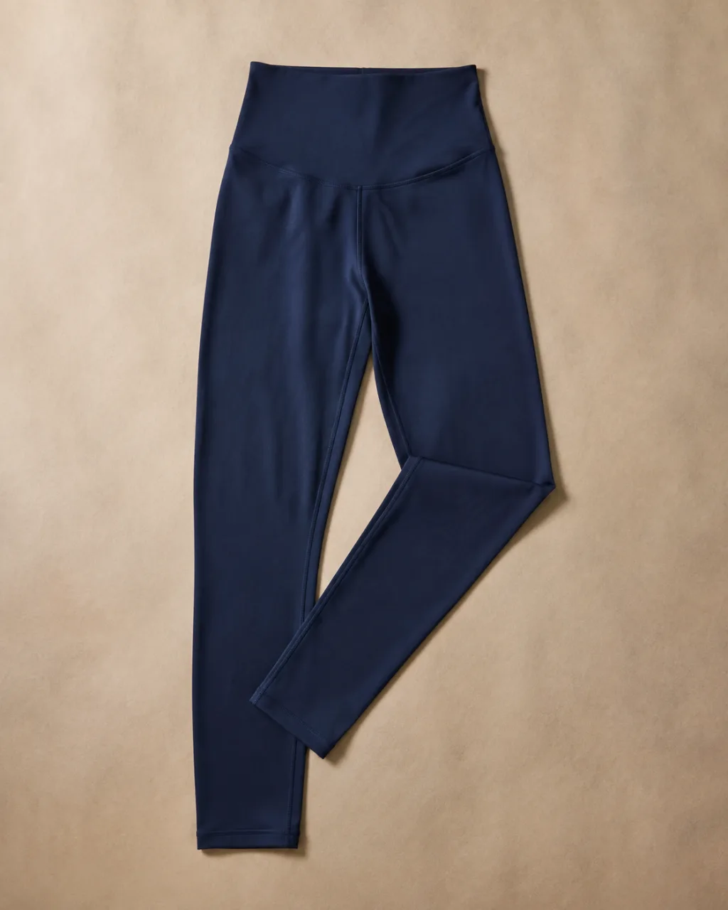 a pair of leggings laid flat with one leg folded back across the other with a high rise and a full elastic waistband , fabric: Nylon/Lycra knit